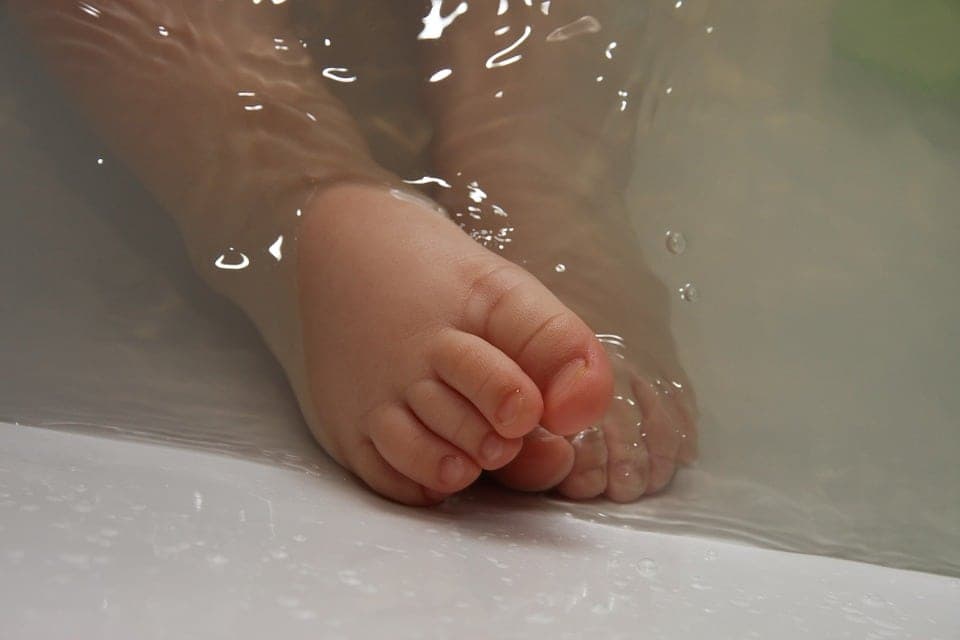 Babies feet in bath water