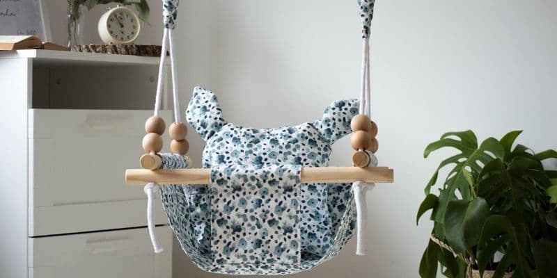 Baby swing chair hanging on ropes.