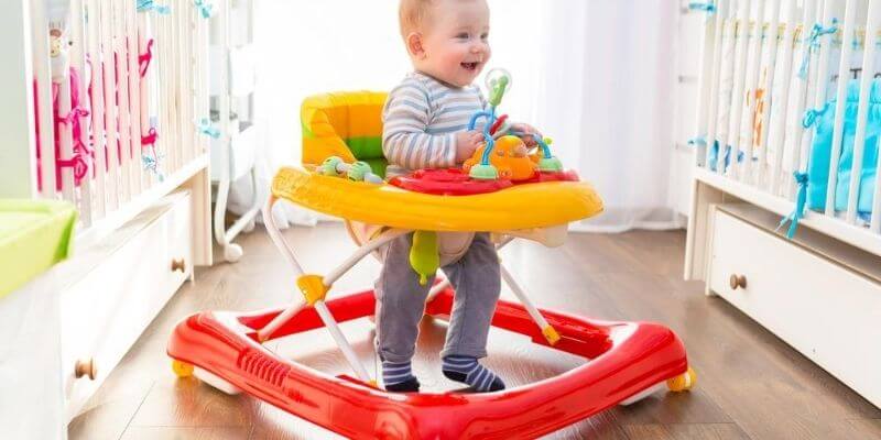 Infant sitting in a baby walker in a nursery room